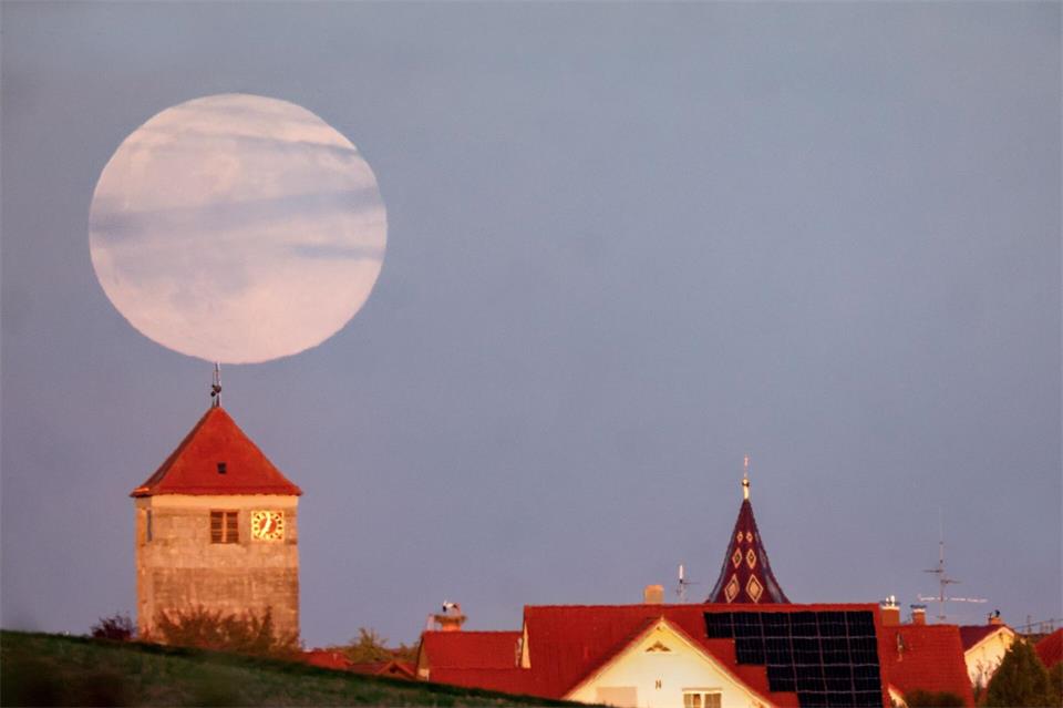 Während der Römerturm in Emerkingen von der Abendsonne angestrahlt wird, geht hinter ihm der Vollmond auf.Thomas Warnack/dpa
