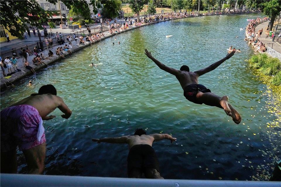 Während einer Hitzewelle springen Menschen in Paris von einer Brücke in den Canal Saint-Martin.Michel Euler/AP/dpa