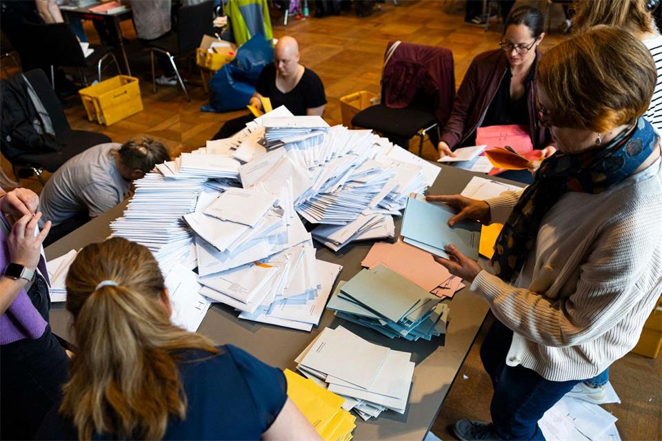Wahlhelfer sortieren die Stimmzettel für die Auszählung der Briefwahl im Neuen Rathaus. Michael Matthey/dpa