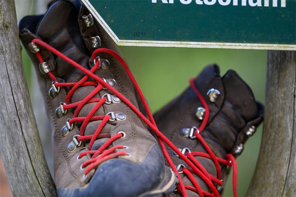 Wanderschuhe stehen in einem Wegweiser am Fuß des Fichtelbergs.Hendrik Schmidt/dpa