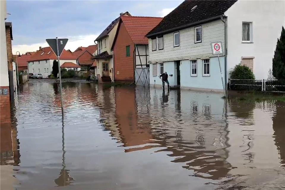 Wasser steht nach einem Unwetter in einer Straße in Anderbeck, in der Gemeinde Huy im Landkreis Harz. (Archivbild)-/Nord-West-Media TV/dpa