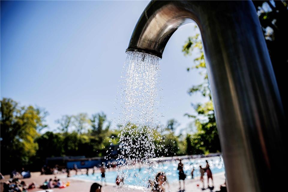 Wasserstrahlen kommen aus einer Wasserdusche im Freibad. Carsten Koall/dpa