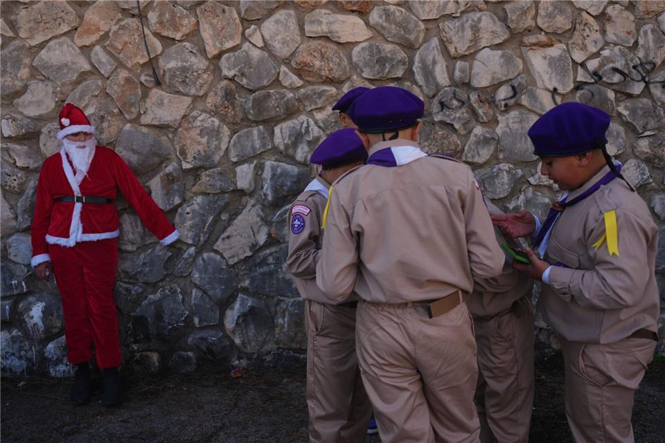 Weihnachten in Nazareth - Jugendlicher im Weihnachtsmannkostüm wartet mit Pfadfindern auf WeihnachtsparadeAriel Schalit/AP/dpa