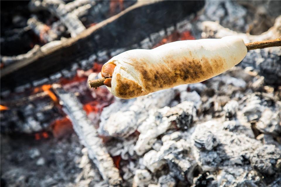Wenn der Teig nicht allein um den Knüppel, sondern auch mit um ein Würstchen gewickelt wird, wird aus dem Stockbrot ein Hotdog.Christin Klose/dpa-tmn