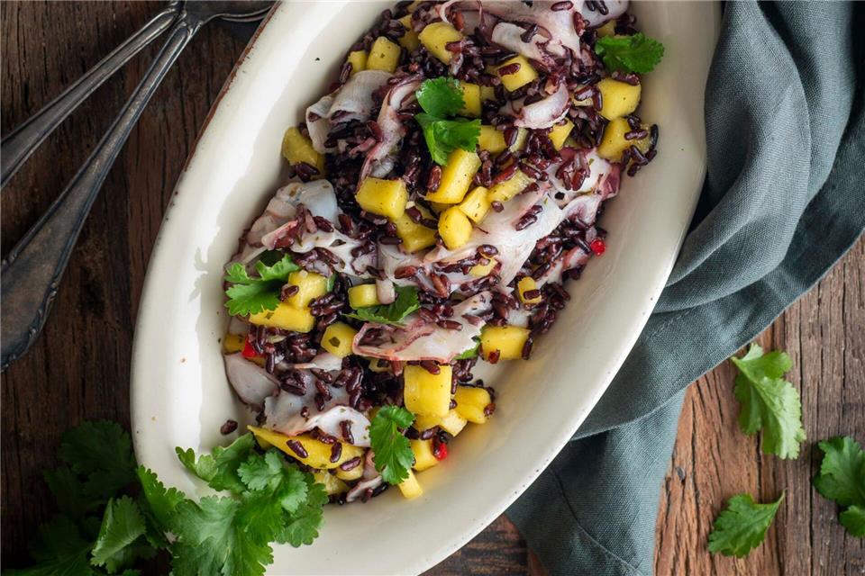 Wenn es mal etwas ganz Exotisches sein soll: Dieser schwarze Reissalat mit Mango und Oktopus sticht auf einer Mitbringfeier sicher heraus.Valerie Hammacher/ars vivendi/dpa-tmn