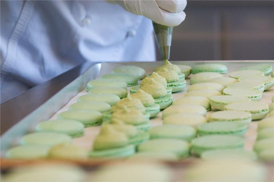 Wenn man Teig oder auch Füllungen für einen Teig mit einem Spritzbeutel und aufgesetzter Tülle aufspritzt oder in Form bringt wie bei diesen Macaronhälften, nennt sich das „Dressieren“. Franziska Gabbert/dpa-tmn