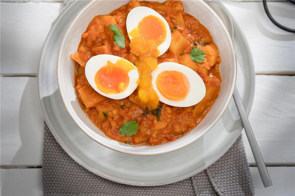 Mit Wurst oder wachsweichen Eiern: Linsen-Kartoffel-Curry Wer dieses Curry fleischlos genießen will, gibt statt Brühwürstchen einfach gekochte Eier hinein.B. L�tke Hockenbeck/LV.Buch/dpa-