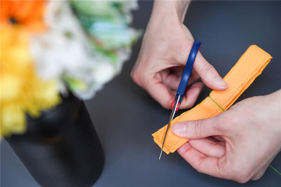 Wer kein Krepppapier hat, kann alternativ eine Serviette wie eine Ziehharmonika falten - dann alles einmal halbieren, mit Draht umwickeln und die Enden spitz zuschneiden.Zacharie Scheurer/dpa-tmn