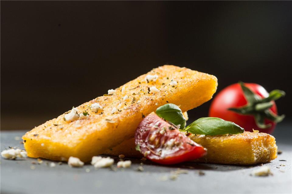 Wer keinen Polenta-Brei mag, kann daraus auch Schnitten machen. Einfach breit streichen, abkühlen lassen und braten. Dazu passen Tomaten, Feta und Basilikum. Franziska Gabbert/dpa-tmn