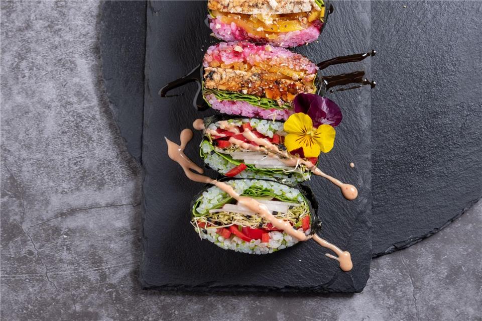 Wer sich für die Vorbereitung etwas mehr Zeit nimmt, kann Sushi-Sandwiches mitbringen - ein hier noch mit essbaren Blüten verzierter Hingucker.Alex Neumayer/Christian Verlag/dpa-tmn