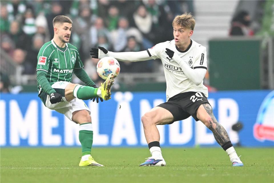 Werders Romano Schmid (l) wird vom Gladbacher Luca Netz gebremst.Carmen Jaspersen/dpa