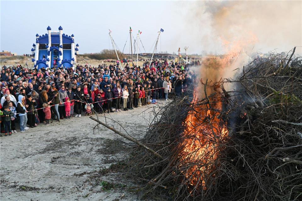 Wie etwa hier in Norddeich ziehen Osterfeuer weiter viele Leute an – ein Ende der Tradition ist laut der Tourismus-Marketinggesellschaft des Landes nicht in Sicht. (Archivbild)Lars Klemmer/dpa