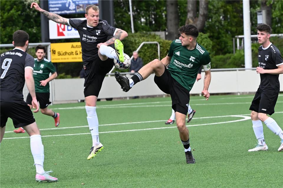 Wie im Fußball-Ballett: Heidens Mike Berger (links) im Zweikampf mit Merfelds Kapitän und Elfmeterschütze Tim Göckener.