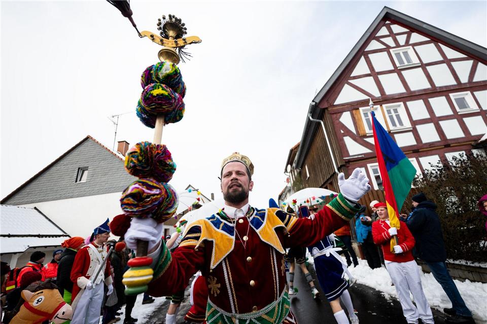 Wie unzählige Bajazze vor ihm führt Julian Herrmann in dieem Jahr am Rosenmontag in buntem Gewand, mit goldener Krone auf dem Kopf und Schellenstab in der Hand, den Springerzug an.Florian Wiegand/dpa