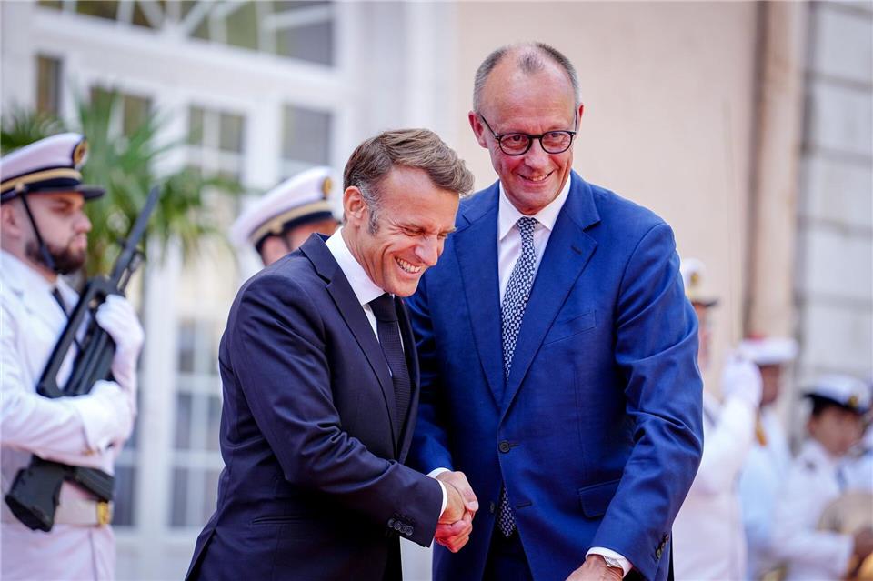 Wie zwei alte Freunde begrüßen sich Macron und Merz vor dem Fort du Cap Brun über der Cote d’Azur.Kay Nietfeld/dpa