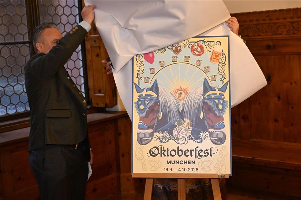Wiesnchef Christian Scharpf enthüllt das zweitplatzierte Motiv. Felix Hörhager/dpa