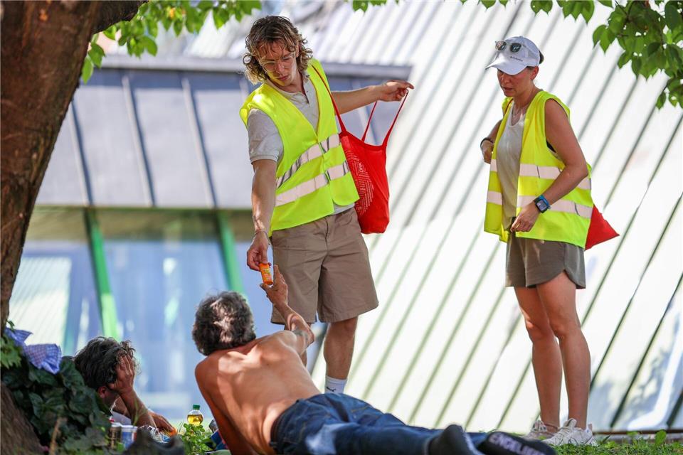 Willi Glück (links) und Janine Funk vom Stuttgarter Hitzebus verteilen Sonnencreme und Wasser an Obdachlose.Christoph Schmidt/dpa