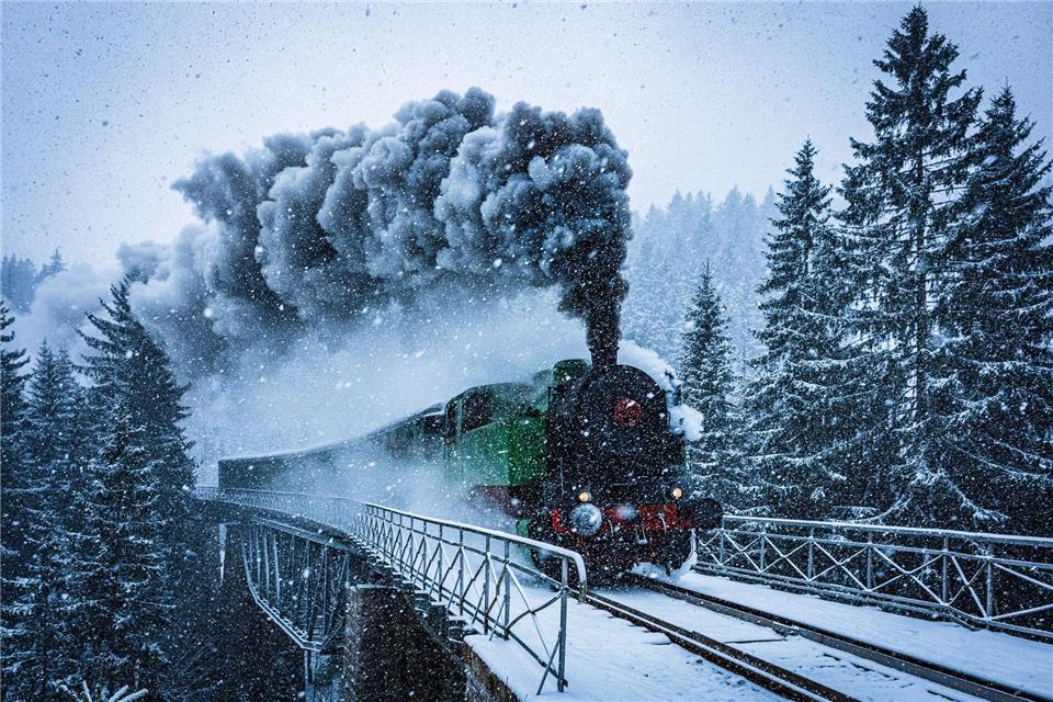 Winterwunderwelt: Eine historische Dampflokomotive fährt in Tschechien durch die verschneite Landschaft.Radek Petrá·ek/CTK/dpa