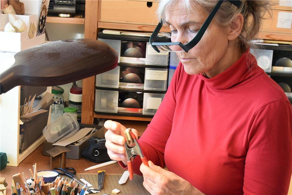 Winzige Bücher mit mehr als 90 Seiten stellt Kathrin Hohensee aus Leipzig her und bringt ganze Städte und Abenteuer in die Puppenstube.Waltraud Grubitzsch/dpa