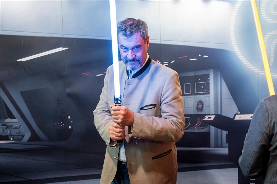 Wohl keine Waffe für den politischen Nahkampf: Markus Söder hält ein Lichtschwert. (Archivbild)Daniel Vogl/dpa