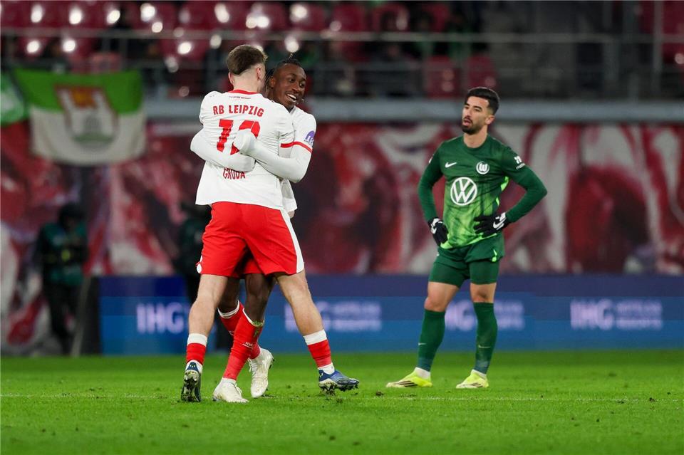 Wolfsburgs Stürmer Mohammed Amoura (r) sieht den Leipzigern beim Jubeln zu.Jan Woitas/dpa