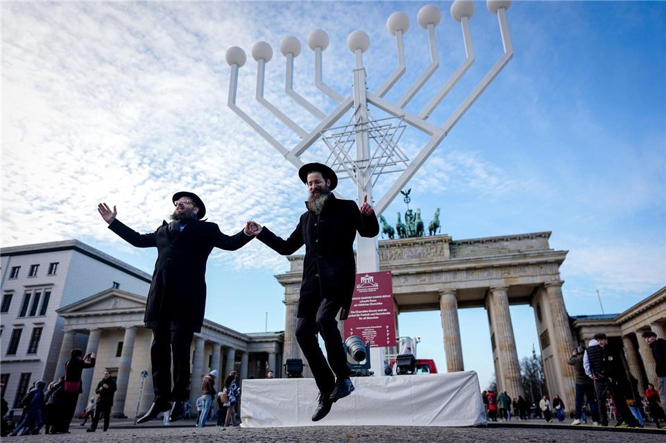 Yehuda Teichtal (l), orthodoxer Rabbiner, und Rabbi Shmuel Segal tanzen bei der Einweihung des Chanukka-Leuchters am Brandenburger Tor in Berlin.Kay Nietfeld/dpa