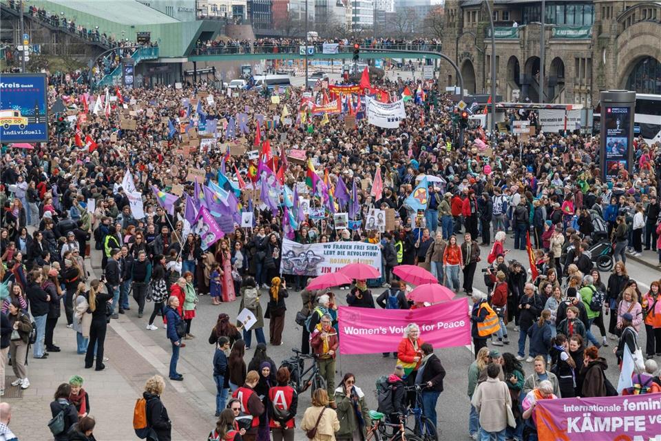 Zahlreiche Fahnen in Rot und Lila werden auf der feministischen Demonstration an den Landungsbrücken gezeigt.Markus Scholz/dpa