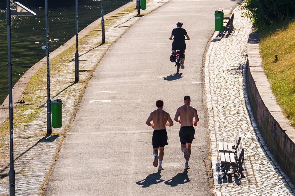 Zeigefreudige Männer mit nacktem Oberkörper und kurzer Hose beim Joggen. (Archivbild)Andreas Arnold/dpa
