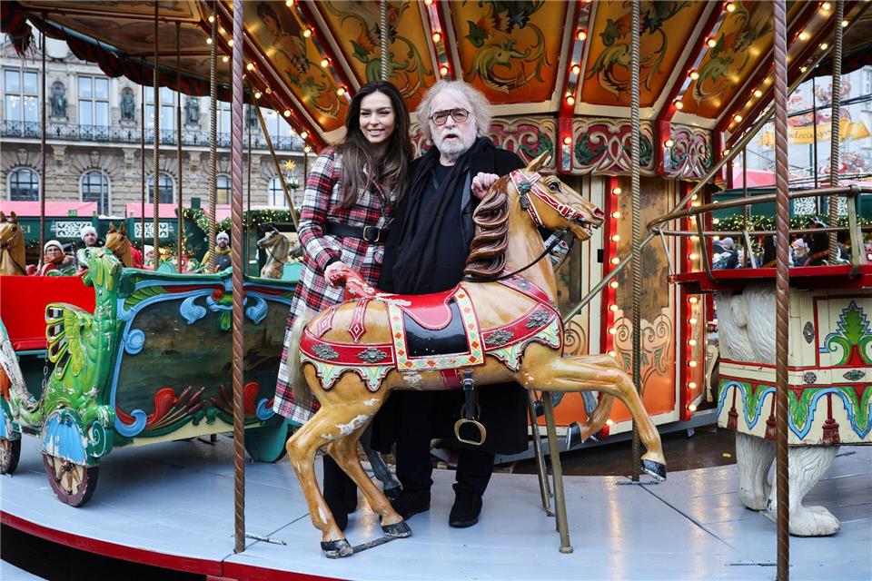 Zirkusdirektor Paul (rechts) und seine Tochter stehen auf dem historischen Karussell des Markts. Christian Charisius/dpa