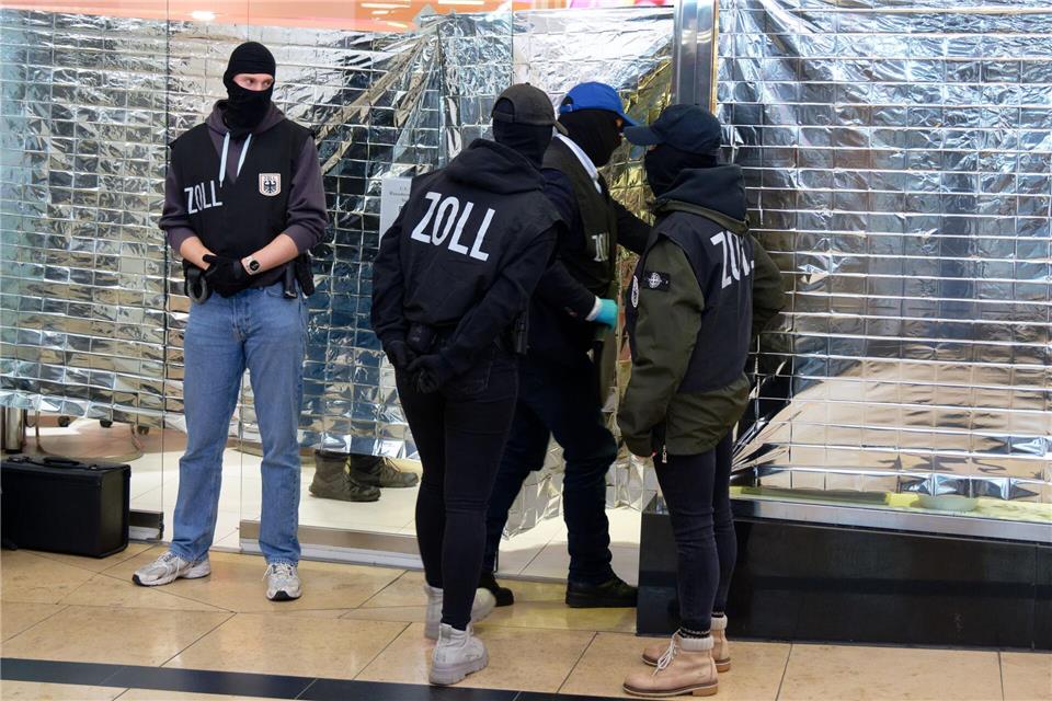 Zollbeamte stehen vor einem Nagelstudio in der Neumarktgalerie in der Innenstadt von Köln.Henning Kaiser/dpa