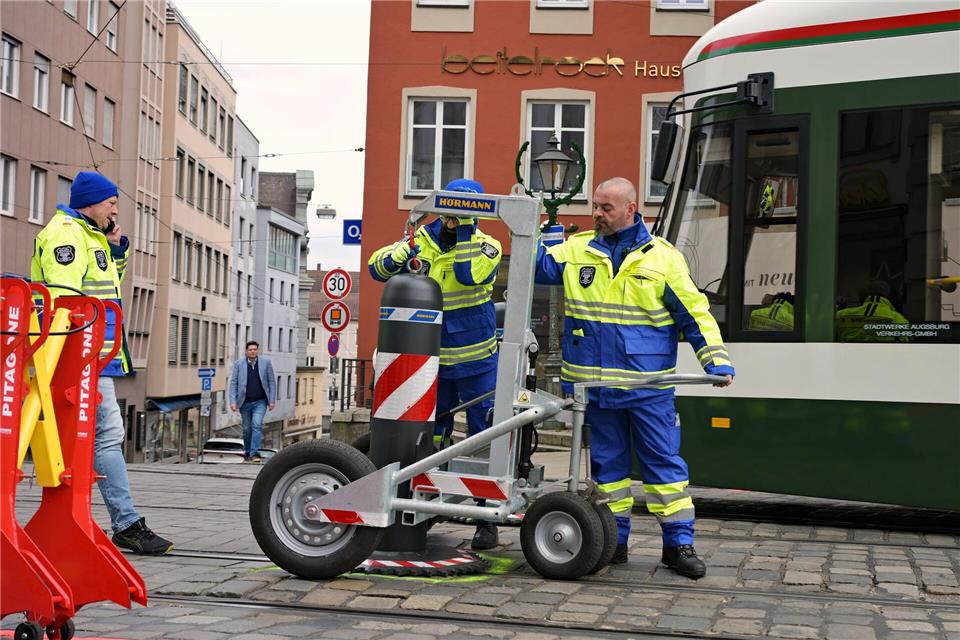 Zu den Hauptverkehrszeiten müssen Sicherheitsmitarbeiter neben dem Augsburger Christkindlesmarkt jede Stunde dutzendfach schwere Poller bewegen, damit die Straßenbahnen durchfahren können.Malin Wunderlich/dpa