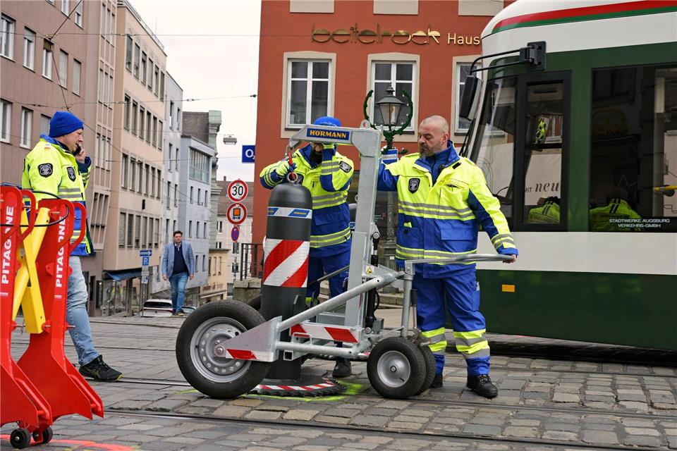 Zu den Hauptverkehrszeiten müssen Sicherheitsmitarbeiter neben dem Augsburger Christkindlesmarkt jede Stunde dutzendfach schwere Poller bewegen, damit die Straßenbahnen durchfahren können.Malin Wunderlich/dpa