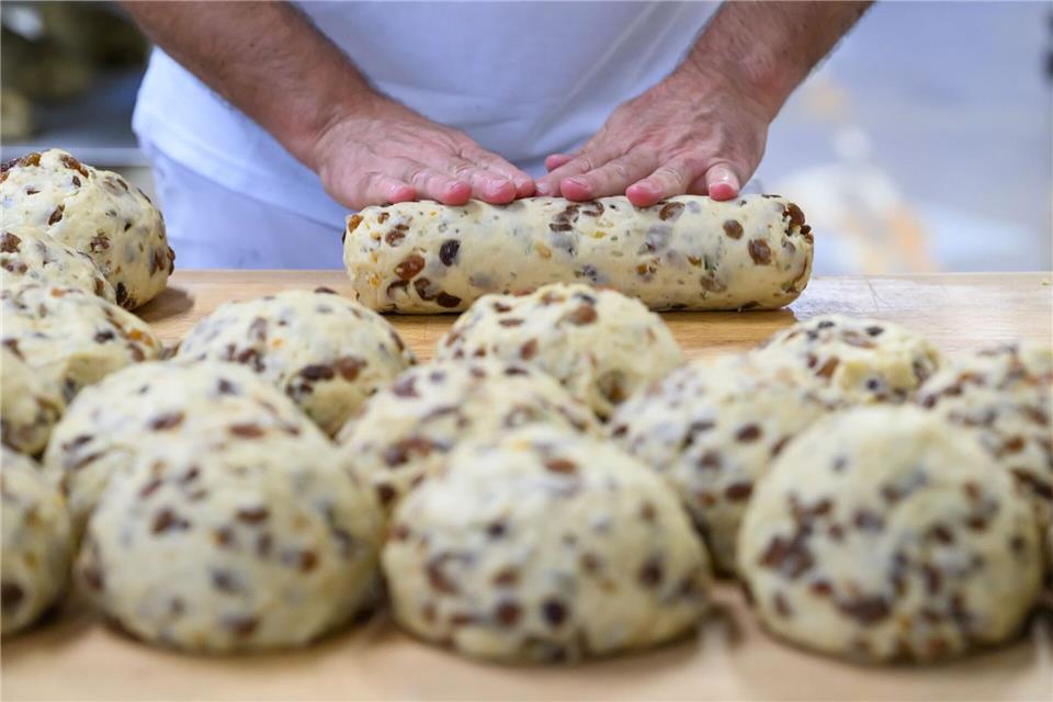 Zuerst werden die Teiglinge für den Dresdner Christstollen geknetet - in Handarbeit.Robert Michael/dpa