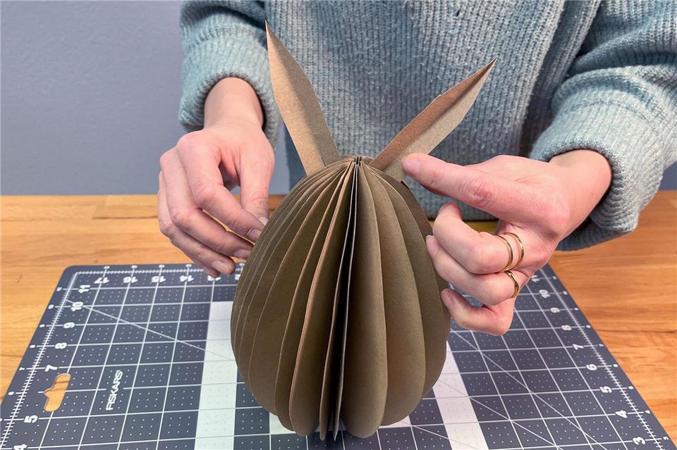 Zum Abschluss zwei Hasenohren basteln und diese an die runde Ei-Form kleben oder einfach in die Falten stecken.DIY Academy/dpa-tmn