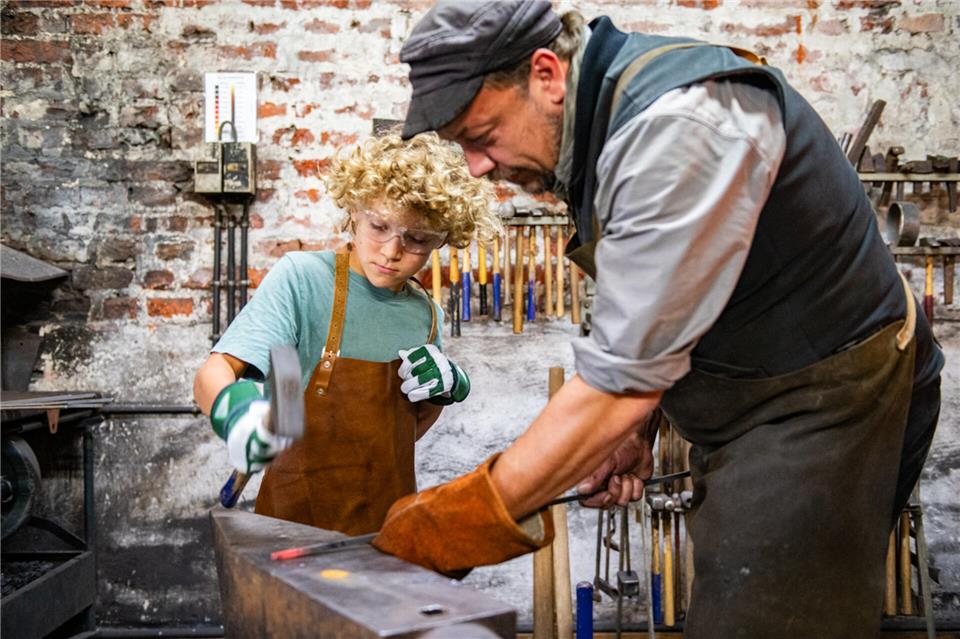 Junge Schmiede formen ein Blütenblatt Zum Schlösser- und Burgentag hatte die Akademie des Handwerks eine Schmiedewerkstatt für Kinder eingerichtet.