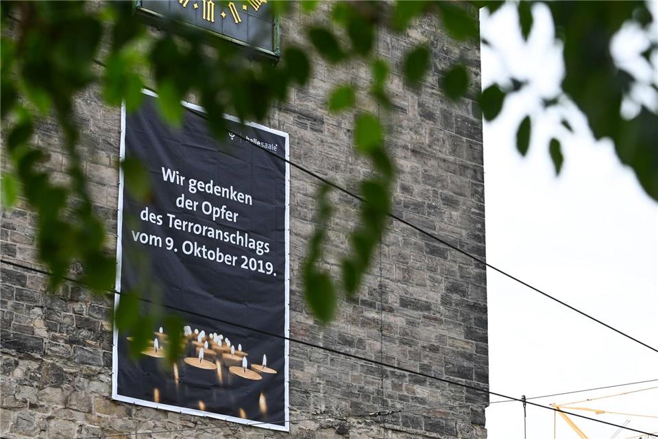 Zum fünften Jahrestag des rechtsextremistischen Terroranschlags in Halle (Saale) hängen an einigen Gebäuden der Innenstadt Plakate zur Erinnerung an die Opfer.Heiko Rebsch/dpa