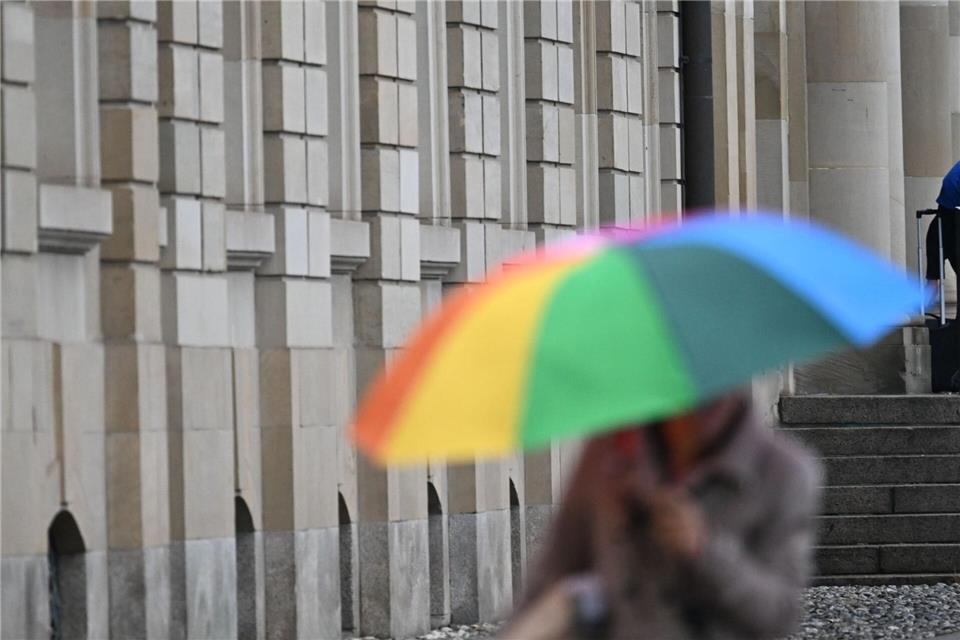 Zumindest ein Klecks Farbe in all dem Grau: Ein kunterbunter Regenschirm. Bernd Weißbrod/dpa