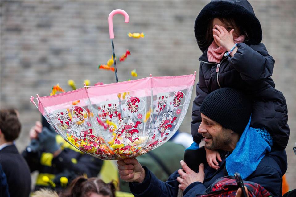Zuschauer können sich beim Umzug in Osnabrück über Süßigkeiten freuen.Friso Gentsch/dpa