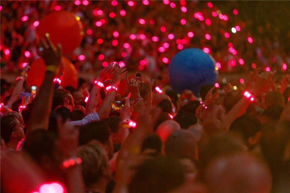 Zuschauer tragen 2024 bei einem Konzert leuchtende Armbänder, die laut Coldplay pflanzenbasiert und kompostierbar sind. (Archivbild)Henning Kaiser/dpa