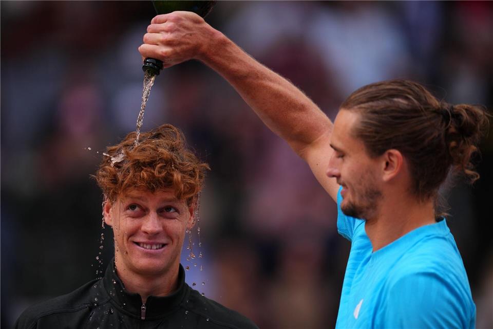 Zverev begießt Sinner mit Champagner. Manu Fernandez/AP/dpa