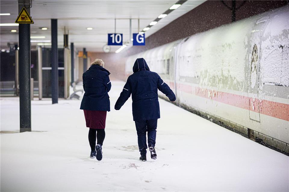 Zwei Bahn-Mitarbeiterinnen laufen am frühen Morgen über den Hauptbahnhof Hannover. Moritz Frankenberg/dpa