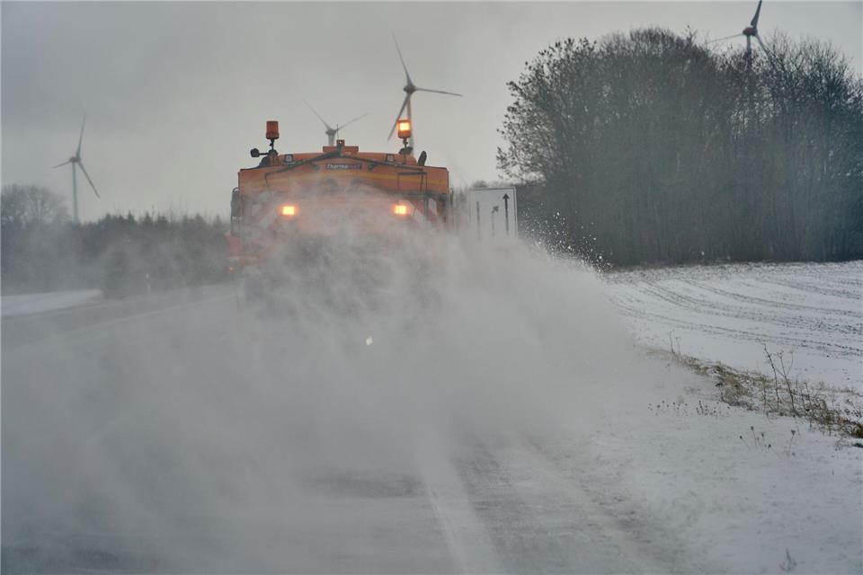 Zwei Fahrzeuge der Straßenmeisterei sind auf der B327 unterwegs, um Schnee und Schneeverwehungen von der Fahrbahn zu beseitigen.Sascha Ditscher/dpa