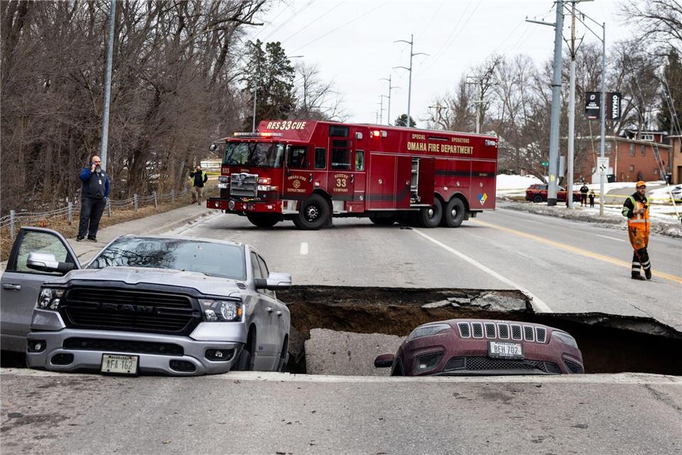 Zwei Fahrzeuge liegen auf der Pacific Street östlich der 67th Street in Omaha in einem Sinkloch.CHRIS MACHIAN/Omaha World-Herald/AP/dpa