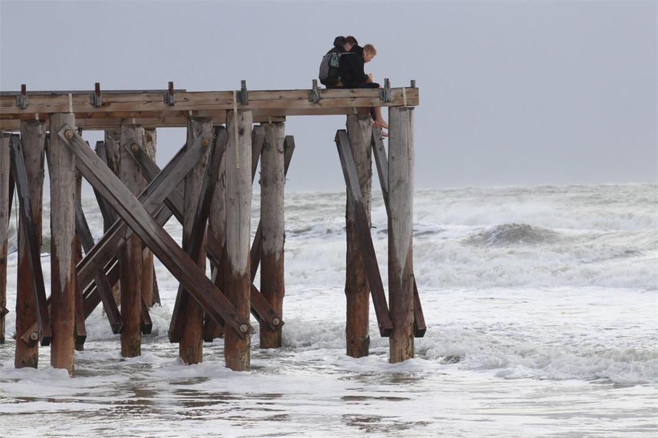 Zwei Jungen beobachten auf der Insel Norderney von oben die stürmischen Wellen.Volker Bartels/dpa