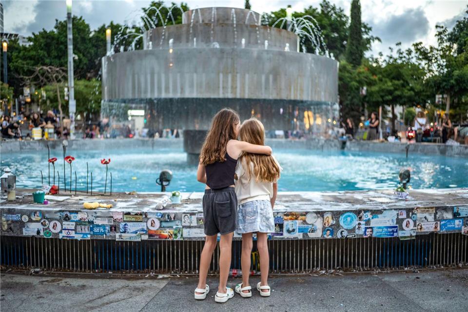 Zwei Mädchen stehen an der Gedenkstätte am Dizengoff-Brunnen in Tel Aviv im Vorfeld des zweiten Jahrestages des Hamas-Anschlags vom 7. Oktober 2023.Ilia Yefimovich/dpa