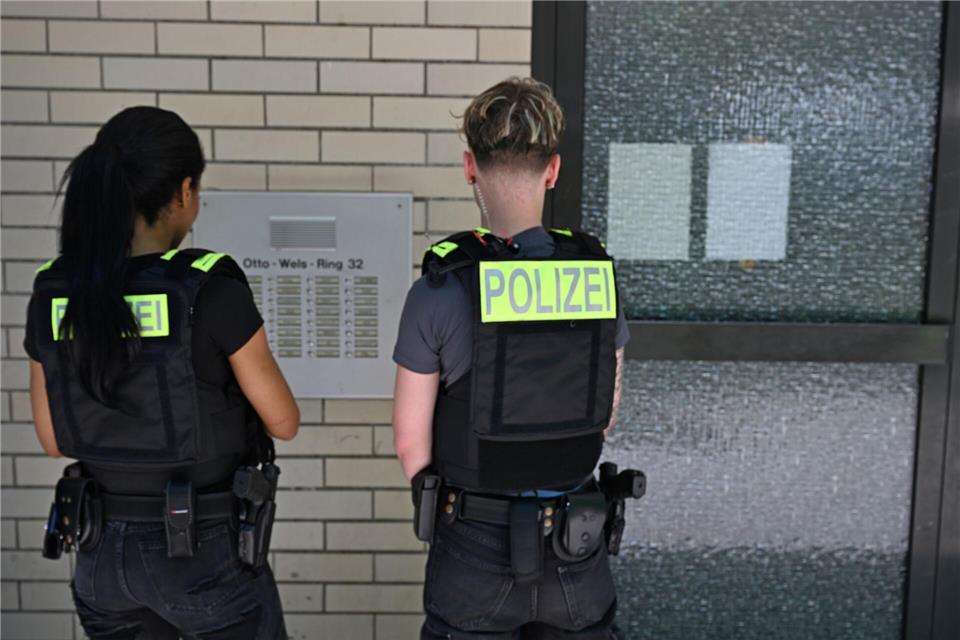 Zwei Polizisten klingeln an Türen von älteren Bewohnern eines Mehrfamilienhauses. Michael Brandt/dpa