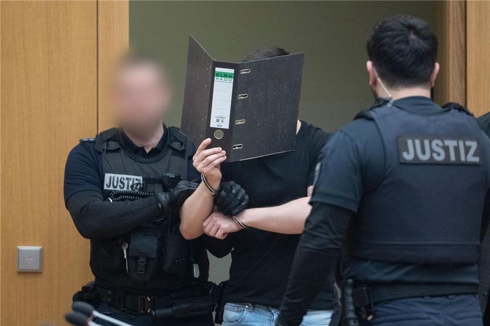 Zwei der Männer verdeckten beim Betreten des Gerichtssaals ihr Gesicht.dpa