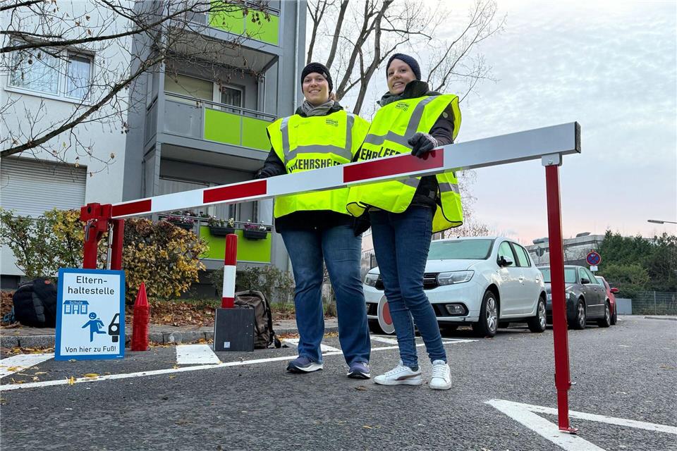 Zwei ehrenamtliche Verkehrshelferinnen stehen an einer Schranke am Beginn einer der neuen Schulstraßen in Frankfurt.Michael Brandt/dpa