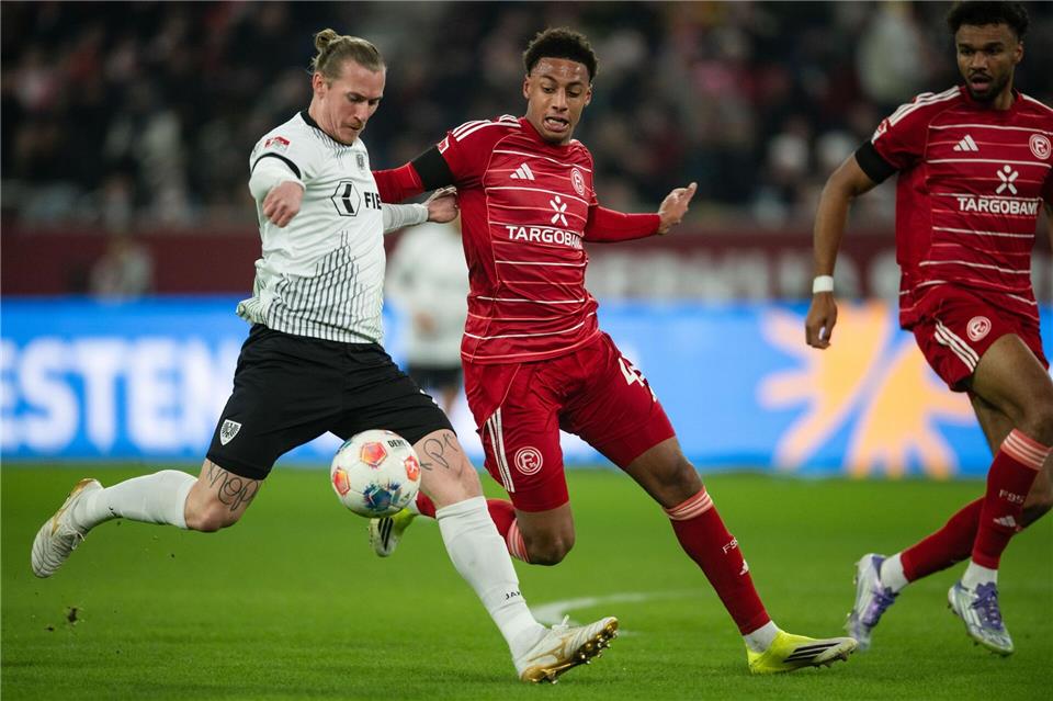 Zweikampf zwischen Münsters Marvin Schulz (l) und dem Düsseldorfer Sima Suso. Marius Becker/dpa