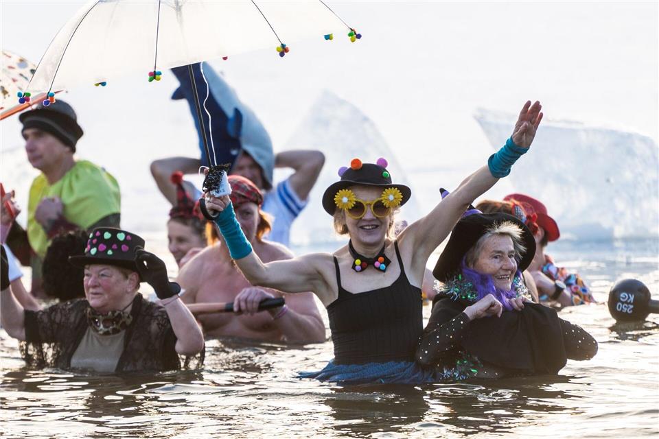 Zwischen Eisschollen standen die Menschen im Wasser.Christophe Gateau/dpa